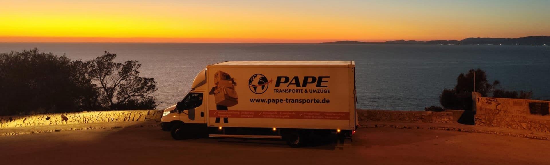 Transport LKW mit Firmenaufschrift vor einem Sonnenuntergang an einer Küstenstraße